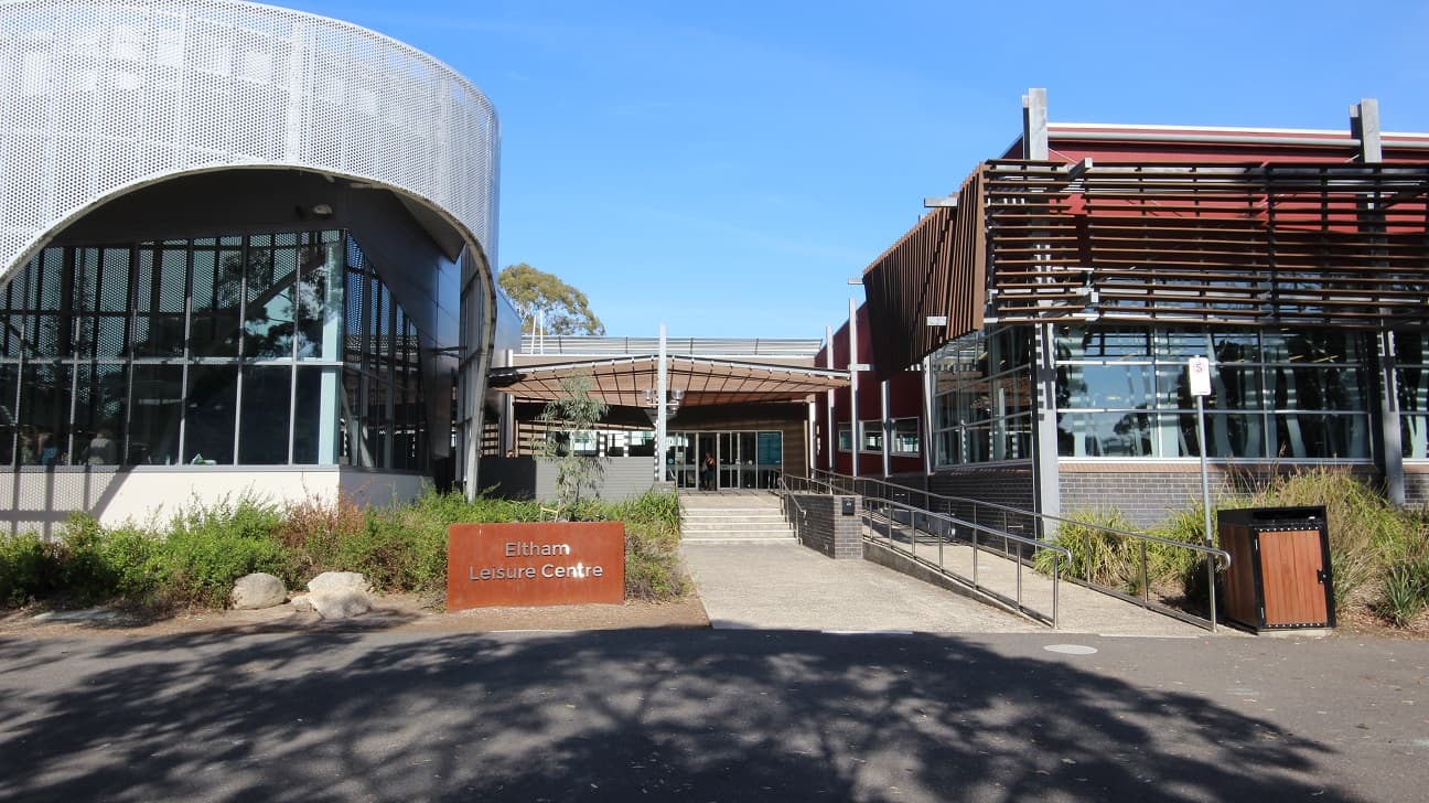 Main entrance of Eltham Leisure Centre is divided by two different architectural designs, which makes the venue stand out. The left wing is made of glass and metal cover containing comb-like holes. The right wing is made of glass and rusty metal cladding.
