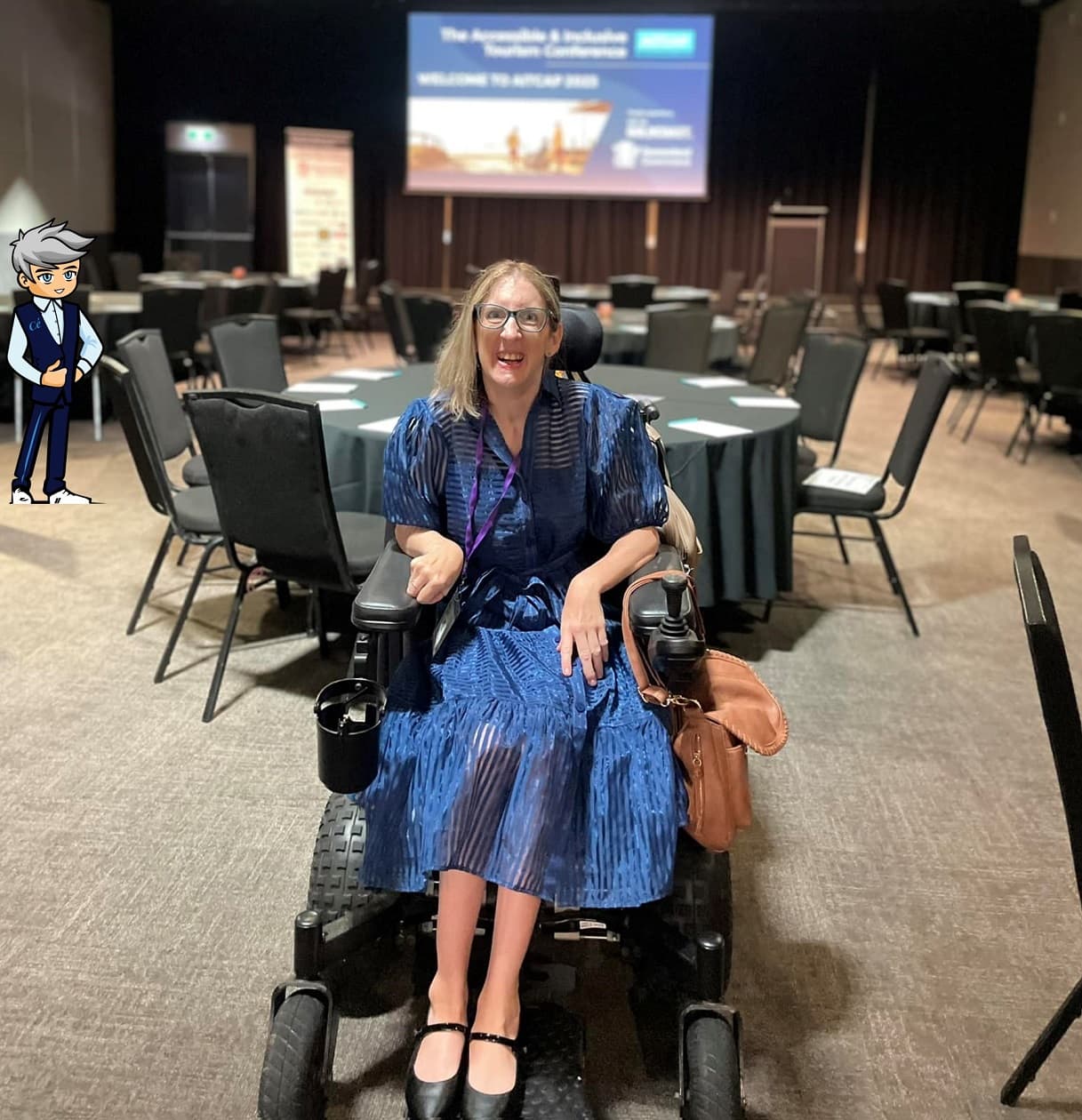 A woman in a wheelchair wearing a blue dress at an indoor event.
