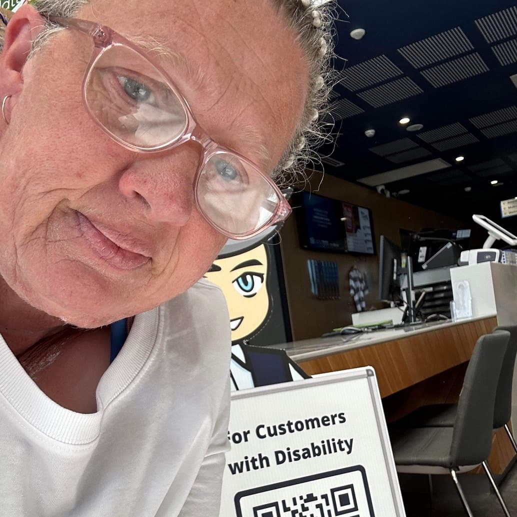 A woman with a child posing beside a Cérge cardboard cutout with a QR sign.

