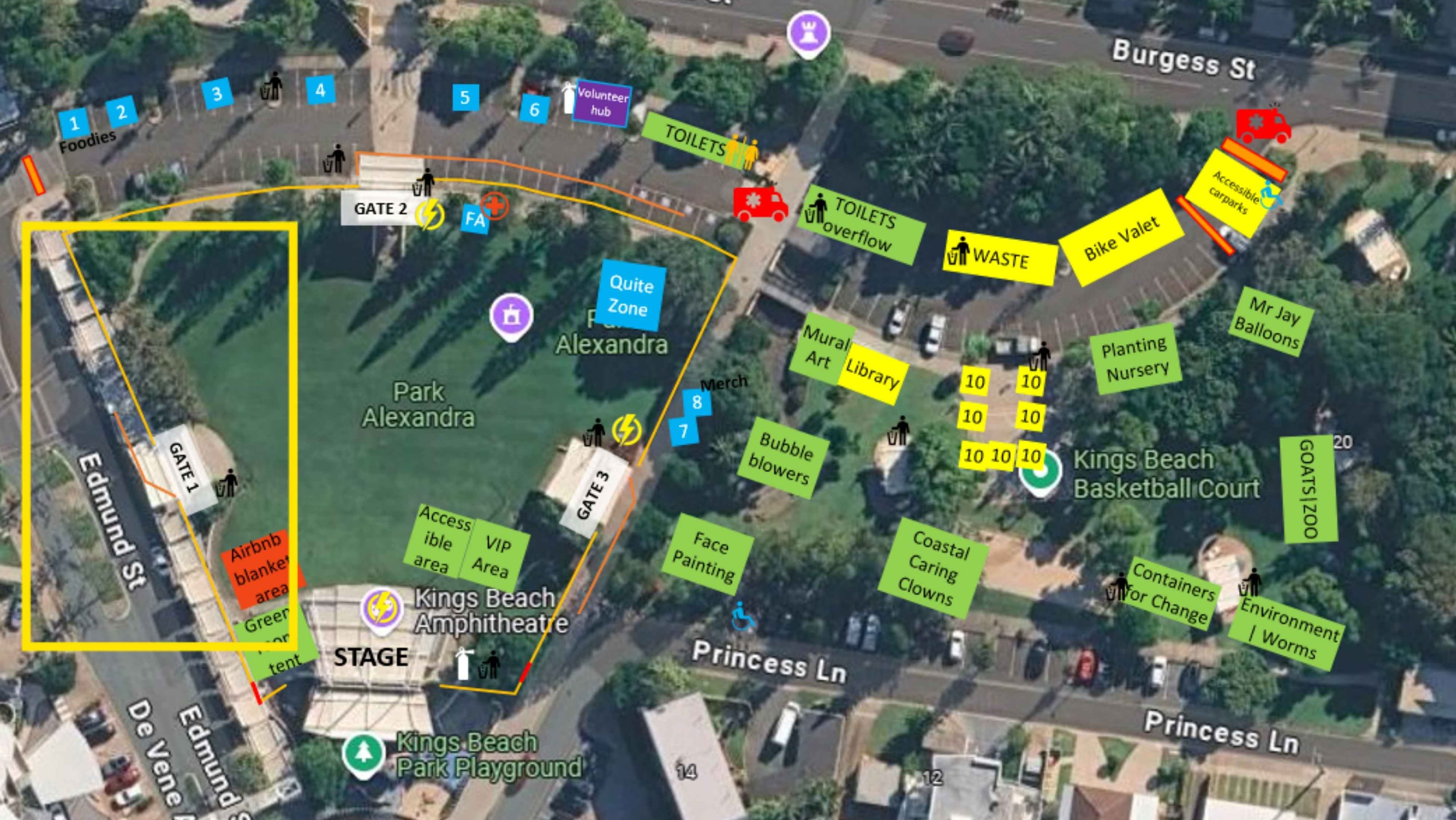 Aerial view of a park layout with a large green central lawn labeled “Kings Beach Amphitheatre” and a stage at the bottom. Left foreground shows a yellow rectangular boundary along Edmund Street and an adjacent walkway; a row of blue numbered markers and a “Toilets” sign near the main gate. Right foreground features a cluster of green signs for facilities and activities near a basketball court; background includes surrounding streets, buildings, and dense tree canopy.