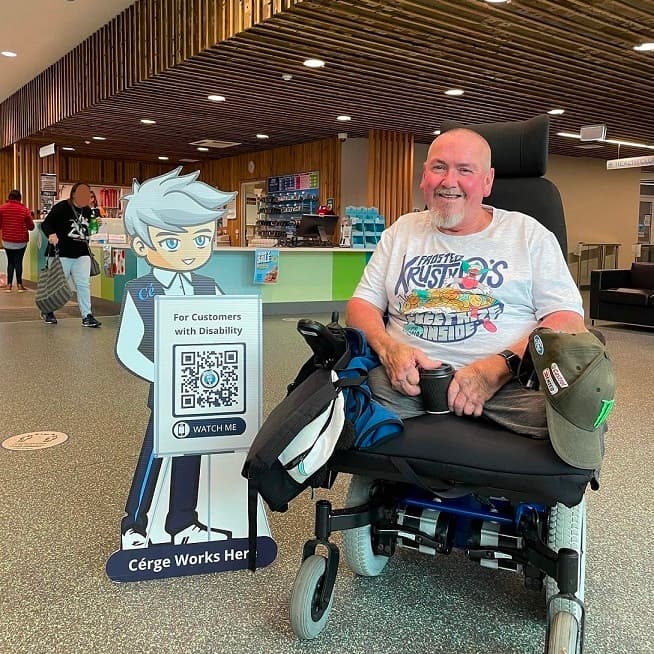 A woman and a child stand outside a pool facility sign that reads "Devonport Aquatic."