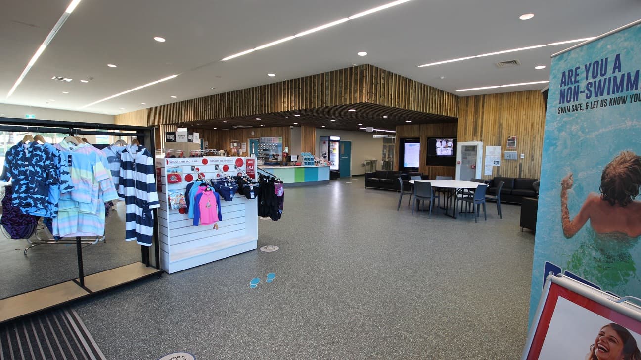 Splash Devonport Aquatic and Leisure Centre logo, as well as water splash designs, can be seen on both sides of the automated glass entry double doors with white edges. Right outside the doors are signboards for the conditions of entry, and do not enter reminders if the guest is unwell. Opening and closing time schedules are also put on the glass doors.
