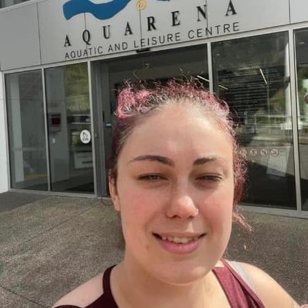 A woman takes a selfie in front of a building.