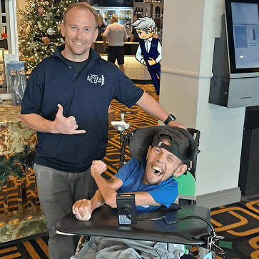 A woman points at a Cérge cartoon cutout in a hotel lobby.