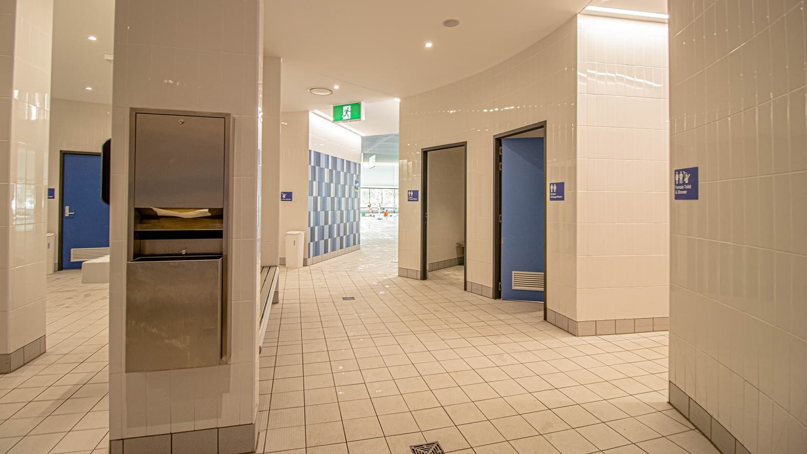 Tissue dispenser is mounted on the wall that separates the toilet rooms at Gurri Wanyarra. Each toilet door is pained in blue and proper signs are attached at the right wall at a perfect height for everyone to see.