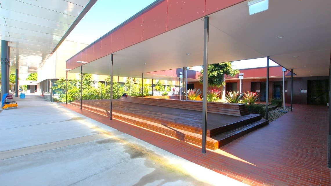 Located outside the bathrooms is a large, open air verandah with a central garden and features dark, wooden surfaces, a thatched roof and spaces to take a seat.
