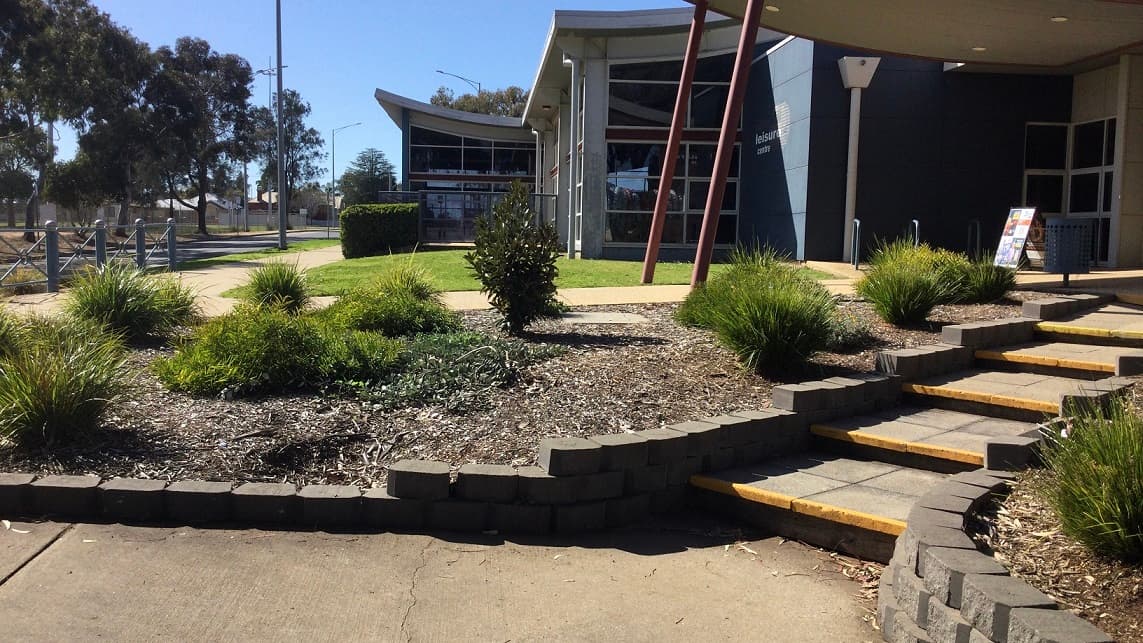 Swan Hill Leisure Centre is a low set grey and blue building that is nestled amongst lush green trees. Access to the centre is via Pritchard Street with parking available in close proximity to the entrance, including a number of accessible car spaces.