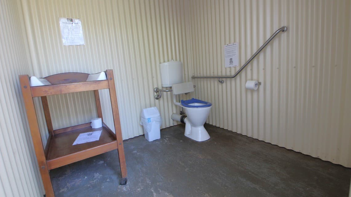 The White Ridge Farm has a bathroom that is painted white. There is a brown-coloured baby changing table. Inside the bathroom is a white and blue low-set toilet with grab rails. Besides the toilet is a garbage bin for disposing of the used sanitary pads. There is a toilet roll hanging in the bathroom and another toilet roll that has been placed beneath the changing table. In the bathroom are three posters placed on the walls.