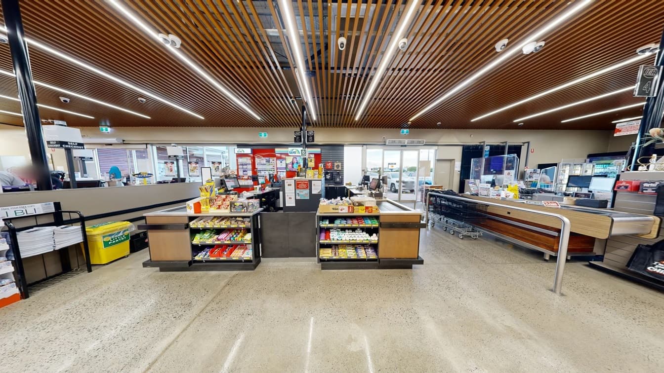 Customer Service desk at White’s IGA Bli Bli. The desk is made of a grey-painted section on the upper part, a well-polished wood supported by metal strips that surround the table. The customer service desk is next to the checkout counters 5 and 6. Right beside the black signboard with the word “Special” on them are blue flags that say, “Low prices”.