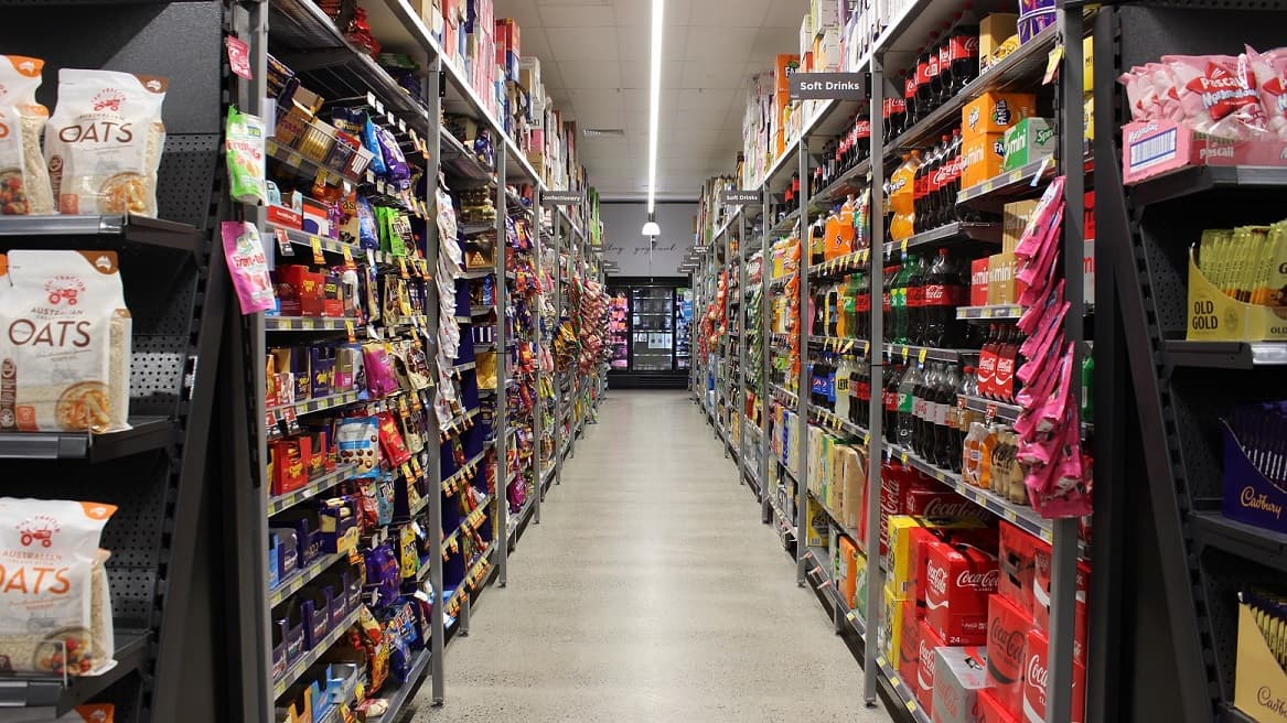 Oats, chocolates, and soft drinks at grey metal racks. These are orderly arrange so that shoppers can easily find and identify them.