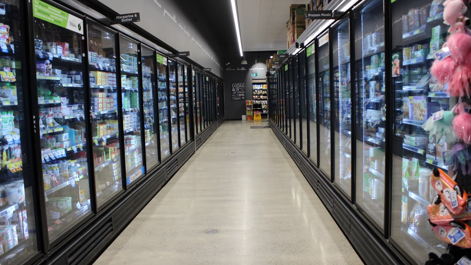 Frozen meals, margarine & butter, and cheese section at White’s IGA Peregian Beach shopping center. The floors are clean and sufficient lighting is provided by a long fluorescent light in the middle of the ceiling.