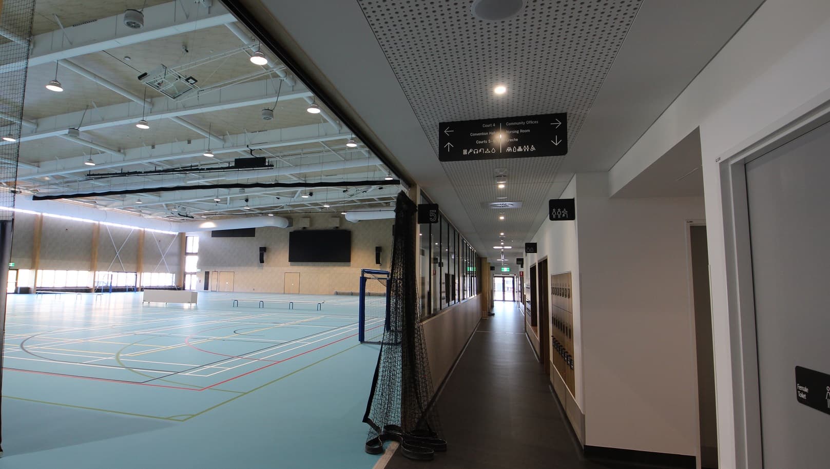 These indoor courts offer a vibrant atmosphere because of the ceiling’s white paint and good lighting. It has a pastel blue-green surface with colorful lines and curves marked on the floor. Its left side has the soccer goal and opposite to it is the glass walls with access doors in the middle. In the partition section of the two courts are available seats and tables.