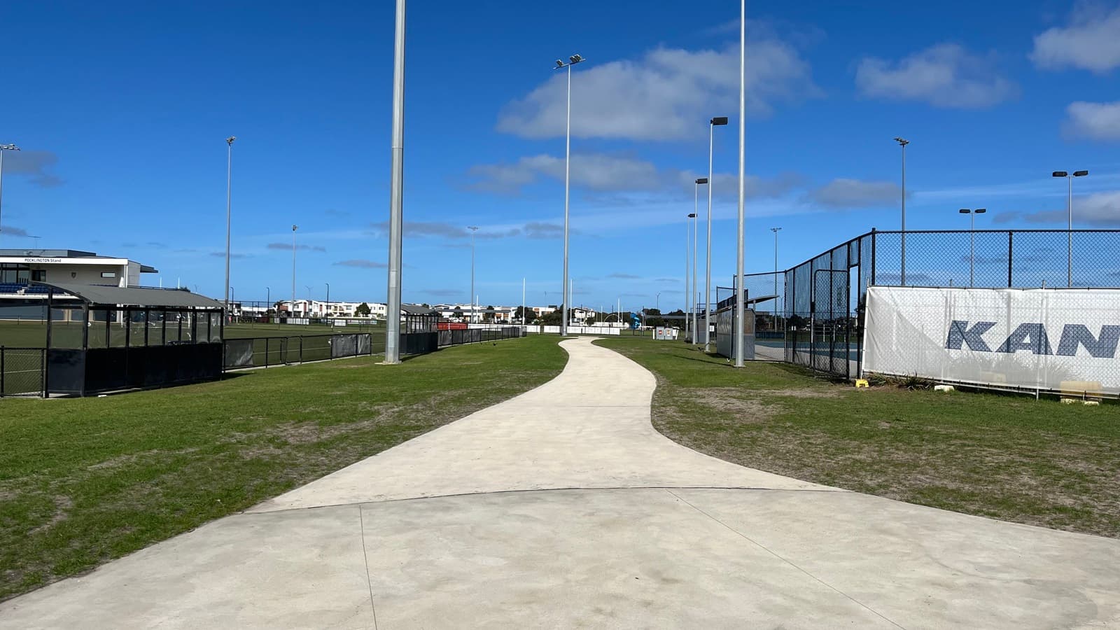 The view of the path from closer to the entrace of Wurdi Baierr stadium. The soccer fields are on the left and the netball courts are on the right. The oval can be seen at the end of the path.