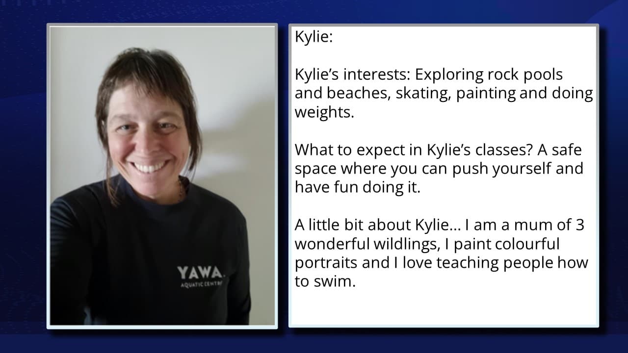 A split image featuring a woman on the left and text on the right. The woman has short dark hair, a visible smile, wearing a dark top, and is pictured from the chest up against a light blue background. On the right, a blue panel contains text introducing "Kylie," detailing her interests in exploring, painting, and doing weights, and describing her personal background and the nature of her classes. The logo "YAWA" appears in the background.